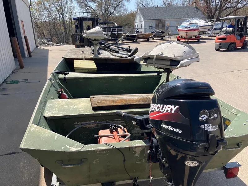 Slide: The Image of 1990 Alumacraft 14' Jon boat with Mercury FourStroke outboard motor, parked outdoors. - 5