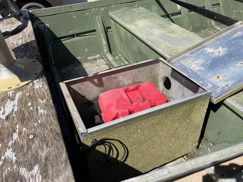 Slide: The Image of 1990 Alumacraft 14' Jon boat with red battery compartment, green interior, and metal seat. - 7