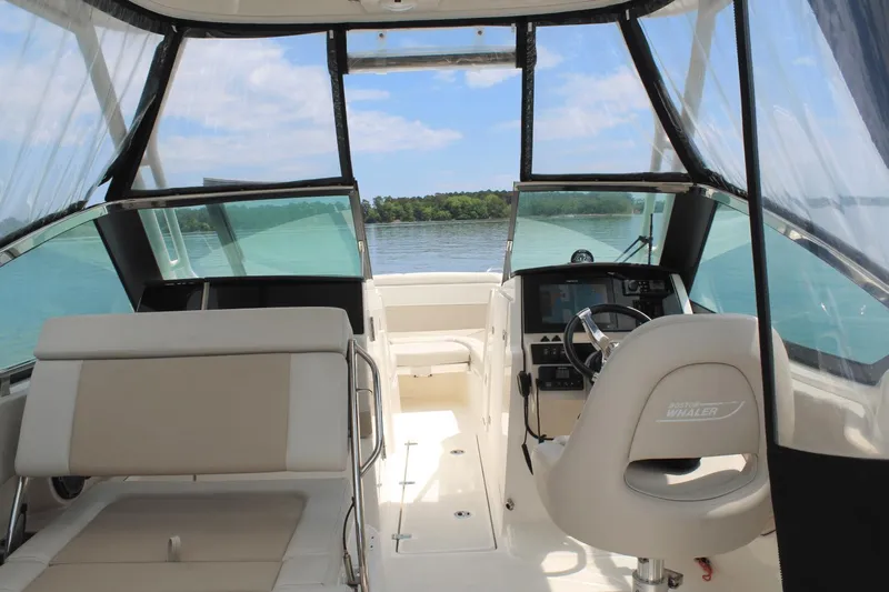 Slide: The Image of 2021 Boston Whaler 240 Vantage boat interior with helm, seating, and water view. - 25