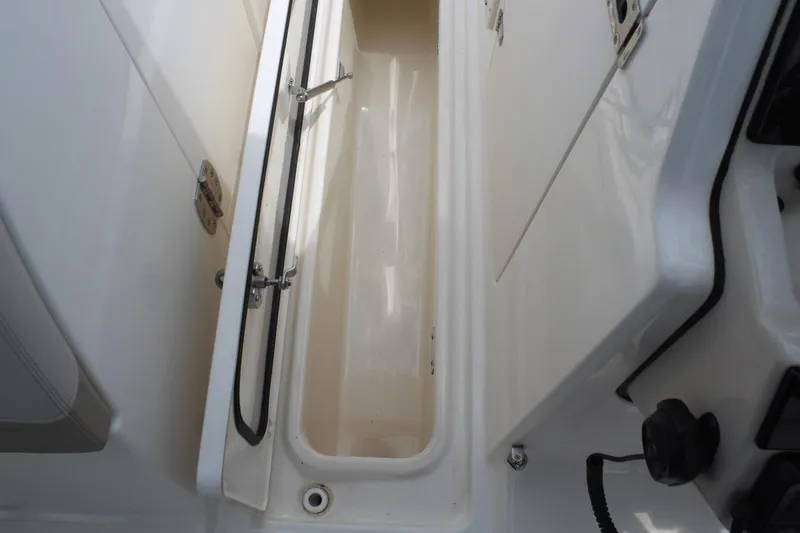 Slide: The Image of 2021 Boston Whaler 240 Vantage storage compartment, open and empty, showcasing interior space. - 34