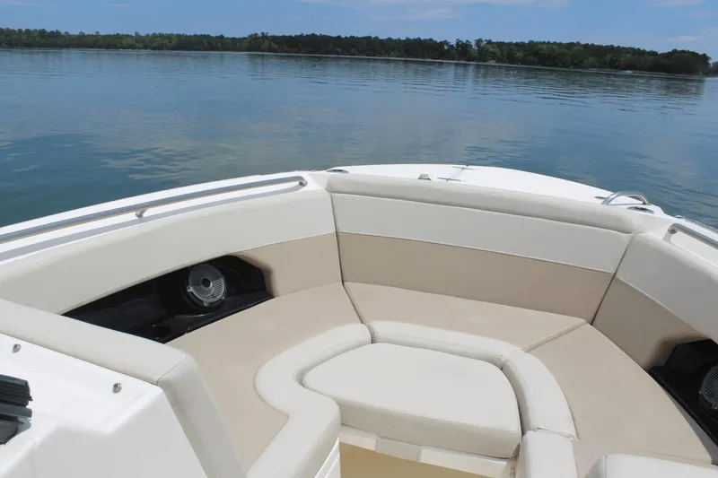 Slide: The Image of 2021 Boston Whaler 240 Vantage boat interior with beige seating on calm water. - 35