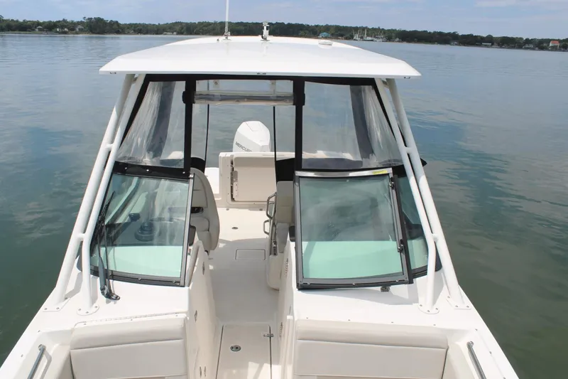 Slide: The Image of 2021 Boston Whaler 240 Vantage boat on calm water, showcasing cockpit and seating area. - 36