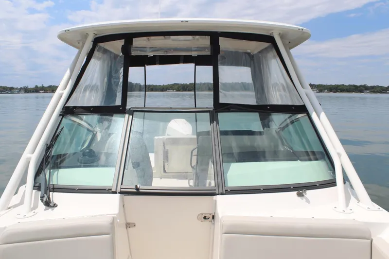 Slide: The Image of 2021 Boston Whaler 240 Vantage boat on calm water, featuring a sleek windshield design. - 42