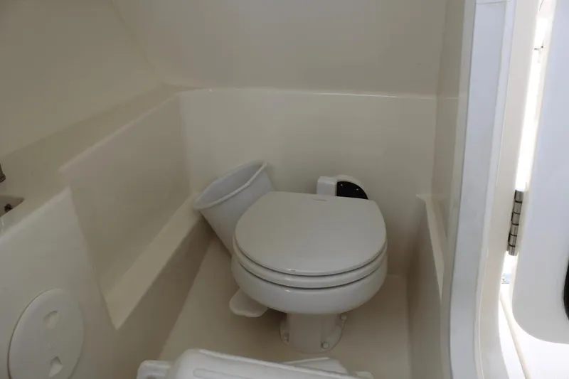 Slide: The Image of 2021 Boston Whaler 240 Vantage boat interior with compact marine toilet. - 46