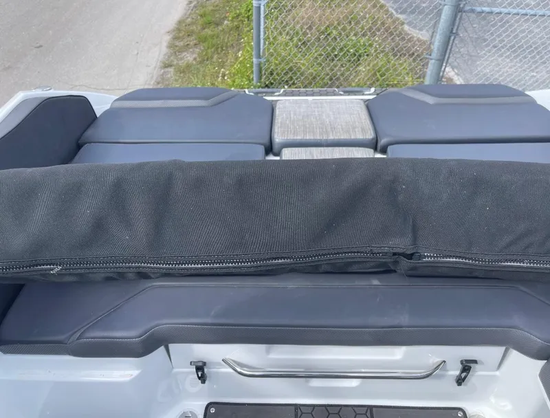 Slide: The Image of 2022 Scarab 255 ID boat interior with cushioned seating and protective cover. - 11