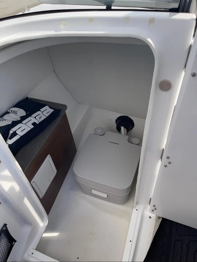 Slide: The Image of Interior of 2022 Scarab 255 ID boat with compact toilet and storage area. - 12