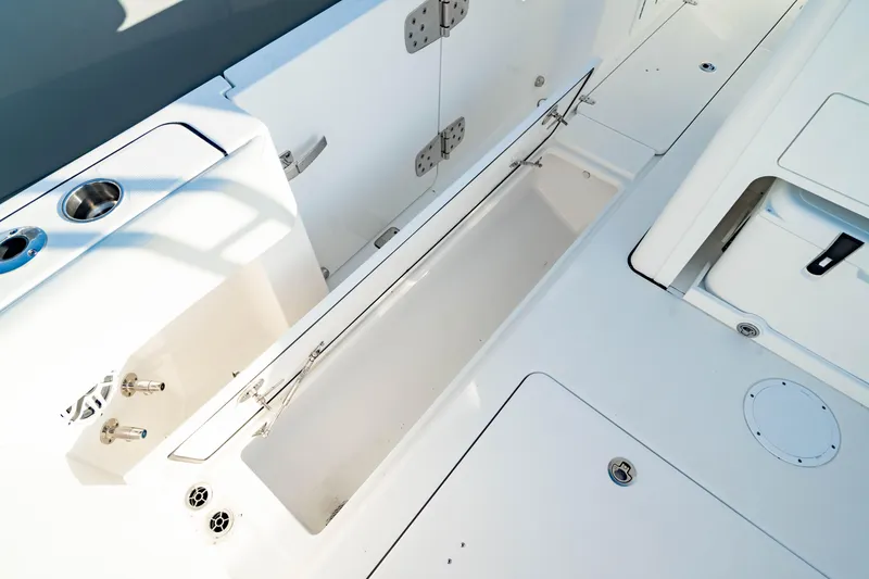 Slide: The Image of 2024 Edgewater 340CC boat interior with storage compartments and cup holders. - 10