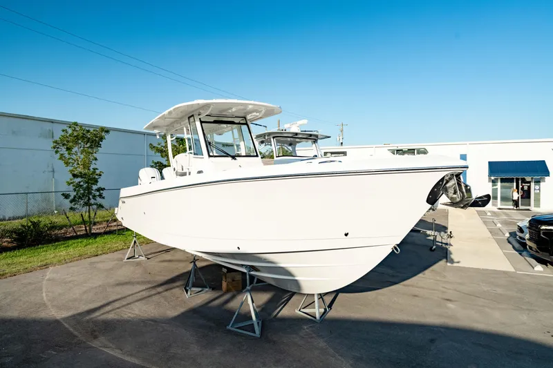 Slide: The Image of 2024 Edgewater 340CC boat displayed outdoors on stands, under clear blue sky. - 12
