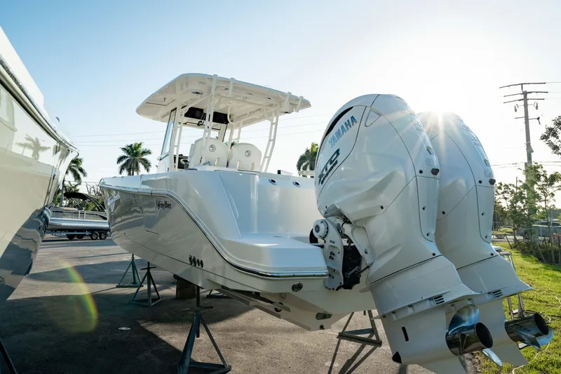 Slide: The Image of 2024 Edgewater 340CC boat with dual Yamaha engines, displayed outdoors in sunlight. - 13