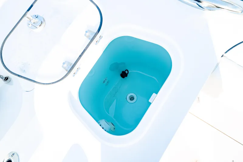 Slide: The Image of Livewell on 2024 Edgewater 340CC boat, featuring a clear lid and blue interior. - 15