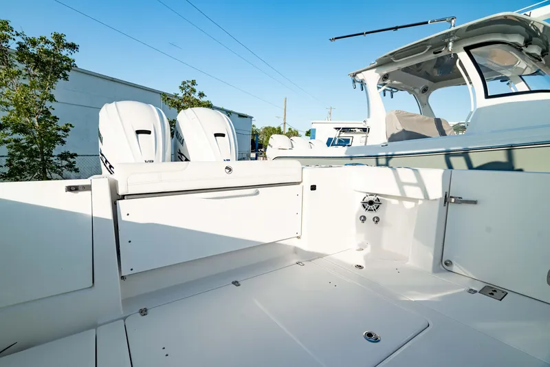 Slide: The Image of 2024 Edgewater 340CC boat deck with dual engines and seating area. - 17