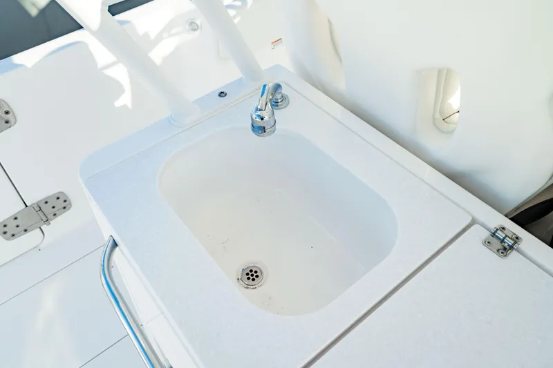 Slide: The Image of 2024 Edgewater 340CC boat sink with faucet, featuring a sleek white design. - 23