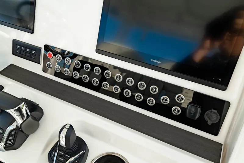 Slide: The Image of 2024 Edgewater 340CC boat dashboard with controls and Garmin display. - 26