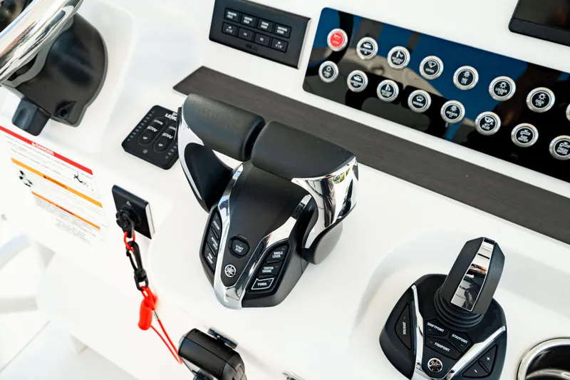 Slide: The Image of Control panel of 2024 Edgewater 340CC boat with advanced throttle and joystick systems. - 29