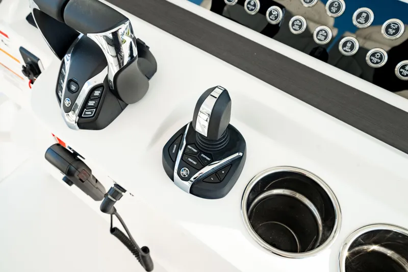 Slide: The Image of 2024 Edgewater 340CC boat controls with joystick and cup holders. - 30