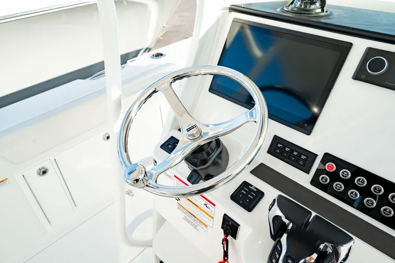 Slide: The Image of 2024 Edgewater 340CC boat helm with modern steering wheel and control panel. - 31