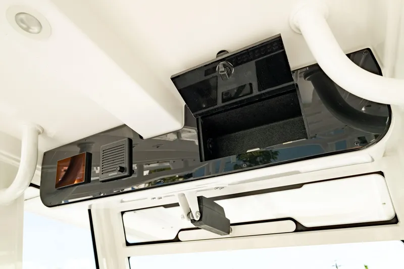 Slide: The Image of 2024 Edgewater 340CC boat console with open storage compartment and electronic controls. - 33