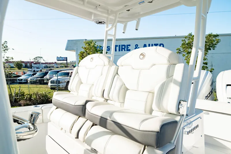 Slide: The Image of 2024 Edgewater 340CC boat with luxurious white seating in a sunny outdoor setting. - 35