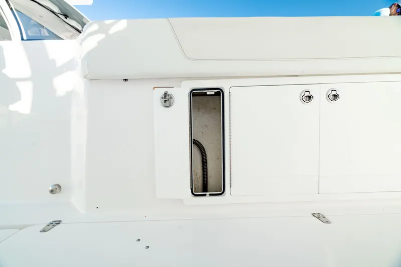 Slide: The Image of 2024 Edgewater 340CC boat storage compartment with white exterior and sleek design. - 37