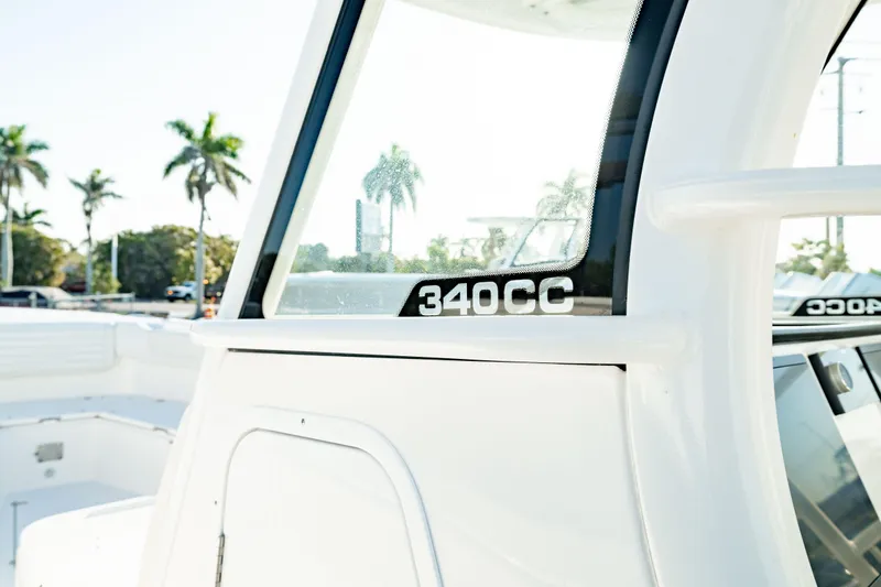 Slide: The Image of 2024 Edgewater 340CC boat with sleek design, palm trees in background. - 40