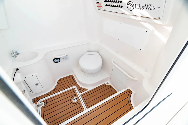 Slide: The Image of 2024 Edgewater 340CC boat interior with toilet and wood-patterned flooring. - 42