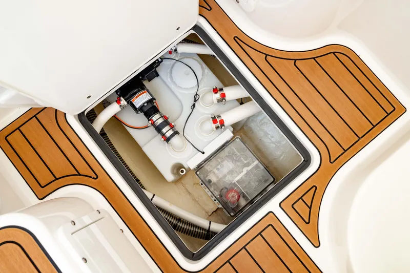 Slide: The Image of 2024 Edgewater 340CC boat interior showing bilge area with pump and wiring. - 44