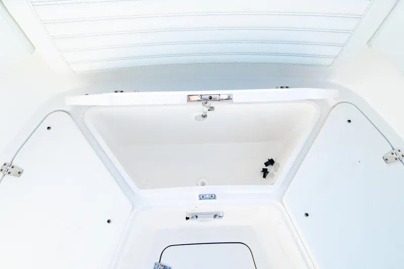 Slide: The Image of 2024 Edgewater 340CC boat storage compartment, open and empty, showcasing interior design. - 49