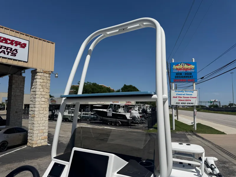 Slide: The Image of 2025 SCB R24 boat with T-top frame near dealership and road signs. - 11