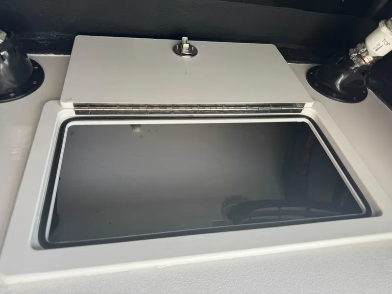 Slide: The Image of 2025 SCB R24 boat compartment with a closed lid and secure latch. - 17