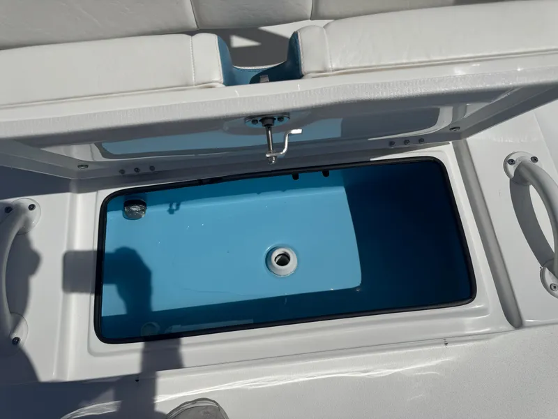 Slide: The Image of Open storage compartment on 2025 SCB R24 boat, featuring a blue interior. - 29
