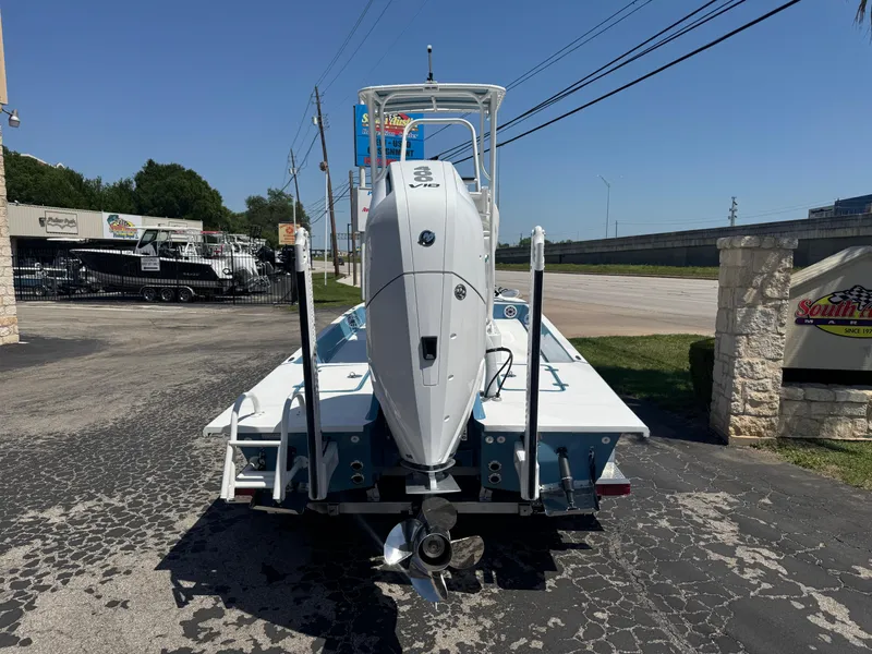 Slide: The Image of 2025 SCB R24 boat with outboard motor, parked on a paved lot under clear skies. - 3