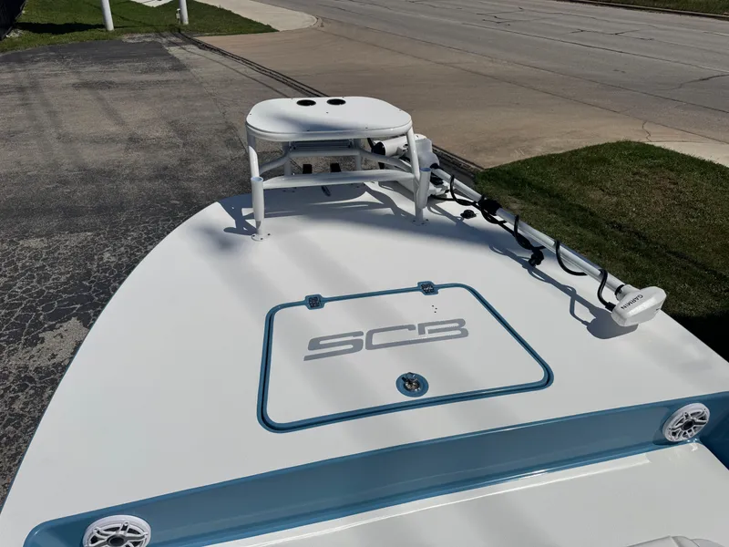 Slide: The Image of 2025 SCB R24 boat deck with mounted equipment and logo, parked on pavement. - 30