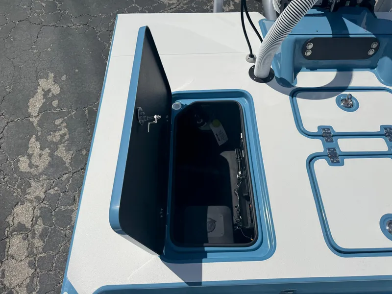 Slide: The Image of Open storage compartment on 2025 SCB R24 boat deck, featuring blue and white design. - 37