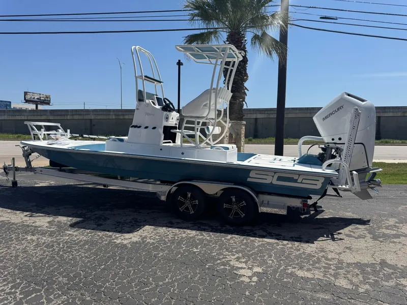 Slide: The Image of 2025 SCB R24 boat on trailer, parked outdoors, featuring a Mercury outboard motor. - 41