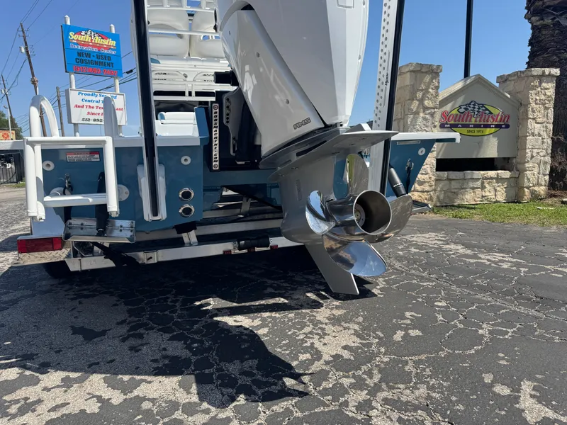 Slide: The Image of 2025 SCB R24 boat with powerful outboard motor and shiny propeller, parked on asphalt. - 5