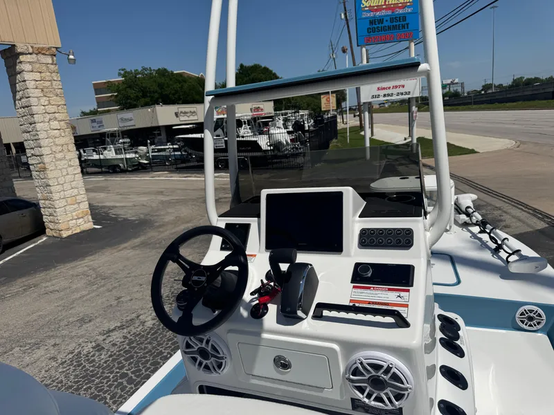 Slide: The Image of 2025 SCB R24 boat dashboard with steering wheel, touchscreen, and controls in a dealership lot. - 6