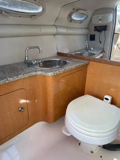 Slide: The Image of 2006 Chaparral 256 SSi boat interior with sink and toilet in compact bathroom. - 17