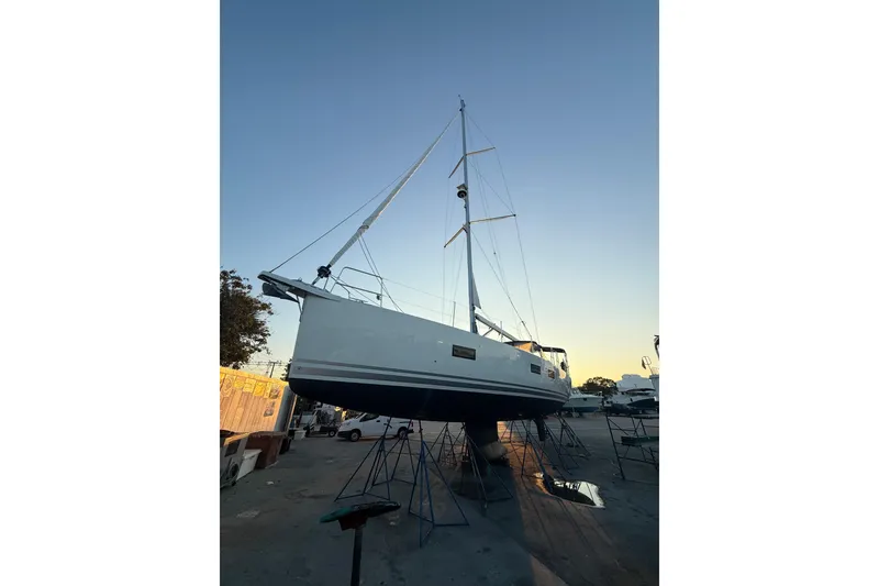 Slide: The Image of Jeanneau 54 sailboat cruising on clear blue ocean under a partly cloudy sky. - 82
