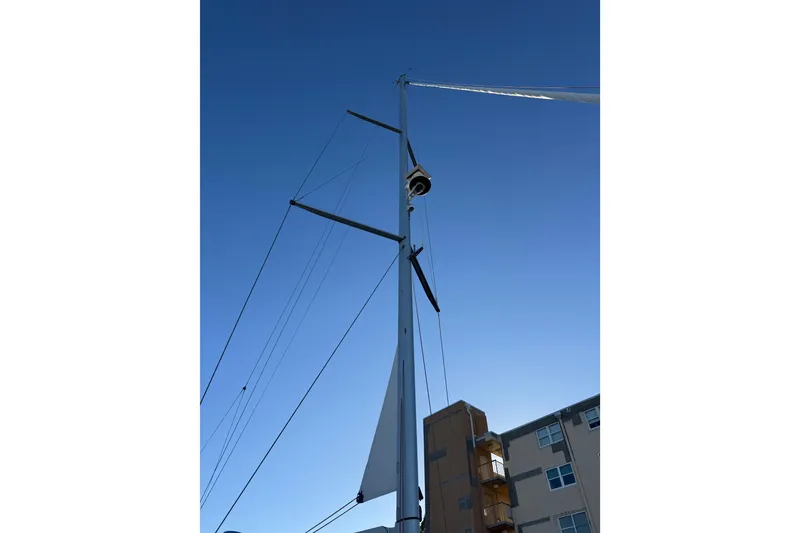 Slide: The Image of Mast of 2021 Jeanneau 54 sailboat against clear blue sky. - 88