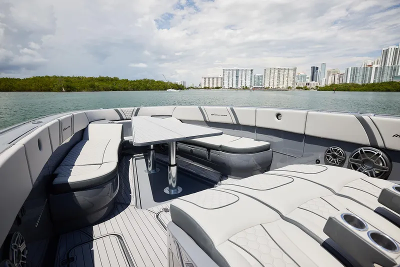 Slide: The Image of Luxurious 2025 Midnight Express 43' Open boat interior with sleek seating and table, city skyline view. - 10