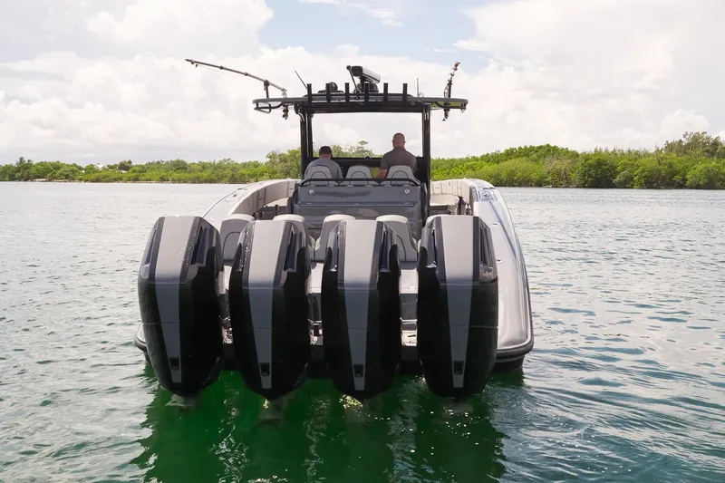 Slide: The Image of 2025 Midnight Express 43' Open boat with five powerful outboard engines on a calm waterway. - 6