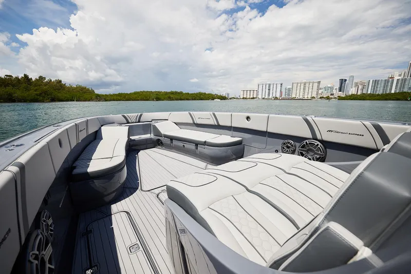 Slide: The Image of 2025 Midnight Express 43' Open boat interior with luxurious seating on a scenic waterway. - 9