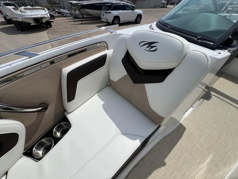 Slide: The Image of 2015 Monterey 218 Super Sport boat interior with white and beige seating, cup holders. - 12
