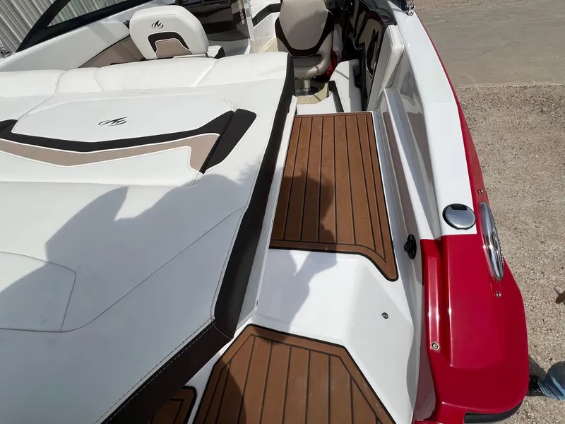 Slide: The Image of 2015 Monterey 218 Super Sport boat interior with white and brown seating, red exterior. - 16