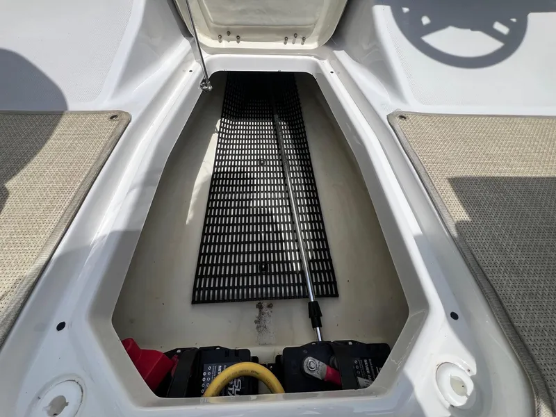 Slide: The Image of 2015 Monterey 218 Super Sport boat storage compartment with battery and wiring. - 29