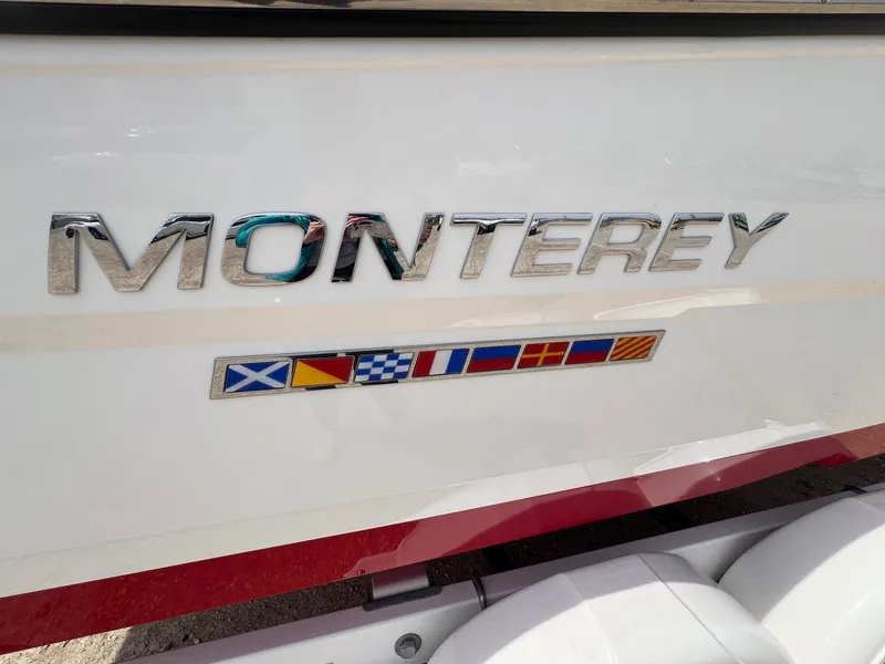 Slide: The Image of 2015 Monterey 218 Super Sport boat logo with nautical flags on white hull. - 4