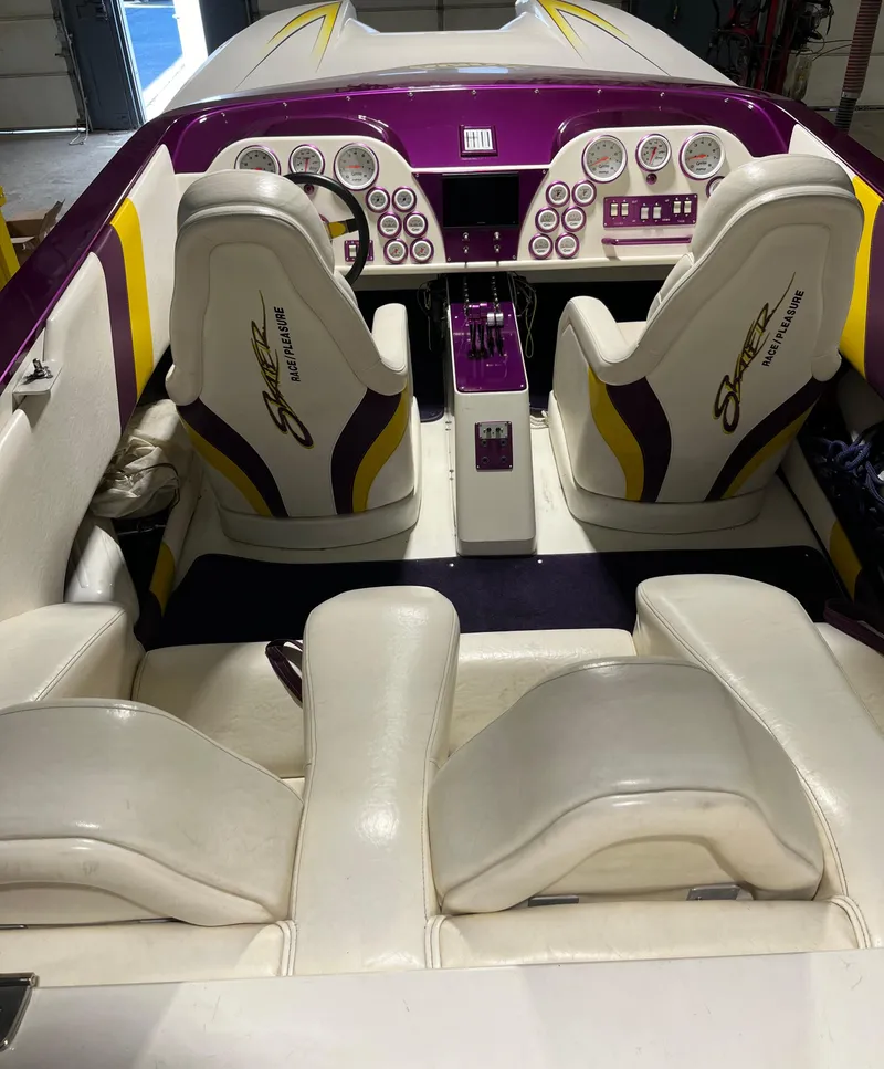 Slide: The Image of 1999 Skater 32B boat interior with white and purple seating, featuring a detailed dashboard. - 10