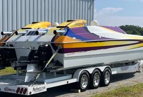 Slide: The Image of Colorful 1999 Skater 32B speedboat on trailer, parked near a metal building. - 3
