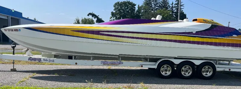 Slide: The Image of 1999 Skater 32B speedboat with vibrant yellow and purple design on a trailer. - 8