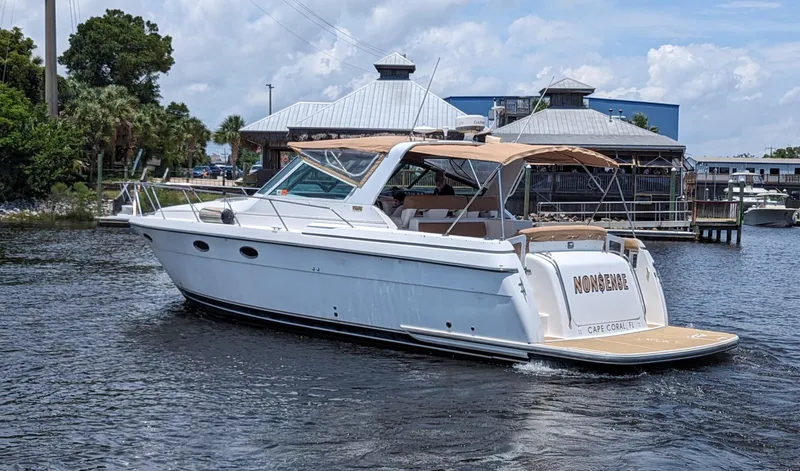 Slide: The Image of 2000 Tiara Yachts 3500 Express cruising on a calm waterway near a marina. - 1